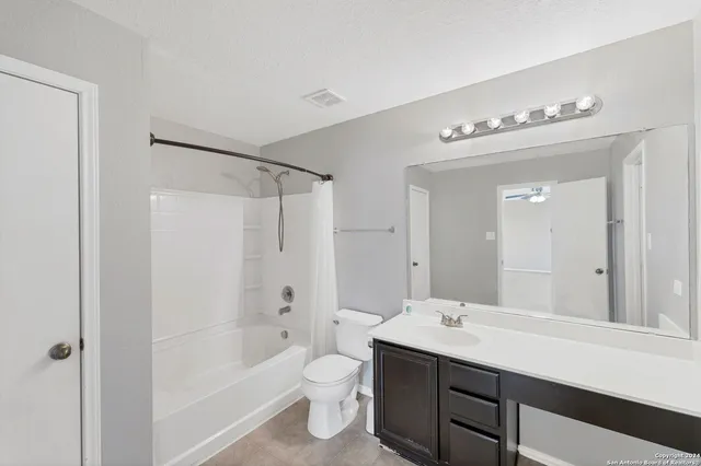 a bathroom with a bathtub shower sink mirror and toilet