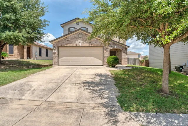 a front view of a house with a yard and trees