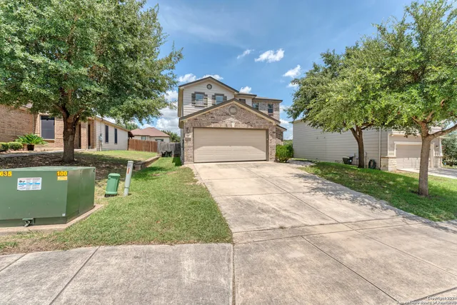 a front view of a house with a yard and trees