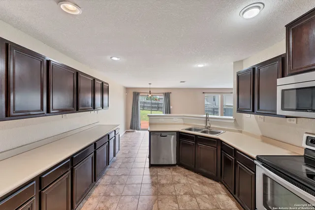 a kitchen with stainless steel appliances granite countertop a sink and stove top oven