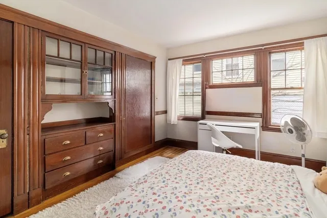 a bedroom with a bed and a dresser next to a window