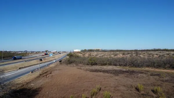 a view of a dry yard with trees