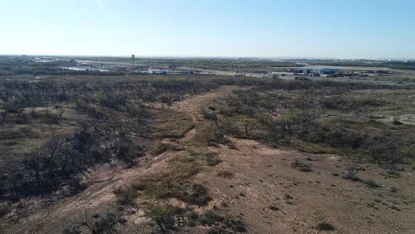 an aerial view of field and trees