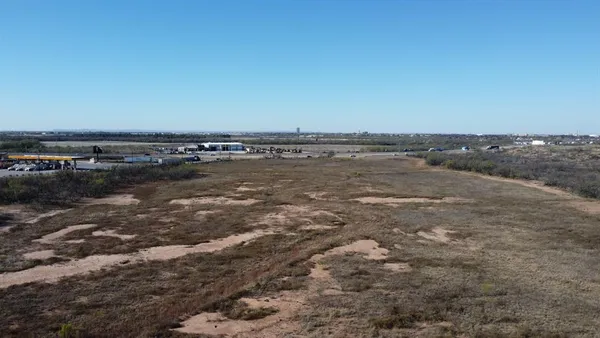 a view of a dry yard with trees
