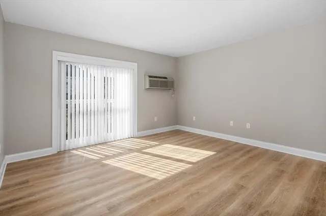 a view of a livingroom with wooden floor and a window