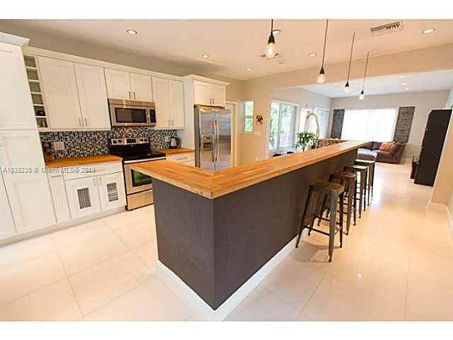 5767 Southwest 35th Street Miami, FL 33155 - Photo 6 of 18 a kitchen with stainless steel appliances kitchen island granite countertop a refrigerator a stove a sink a dining table and chairs with wooden floor