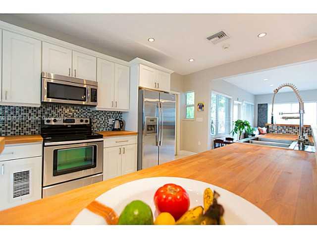 5767 Southwest 35th Street Miami, FL 33155 - Photo 7 of 18 a kitchen with stainless steel appliances kitchen island granite countertop a stove a sink dishwasher and a microwave with wooden floor