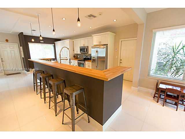 5767 Southwest 35th Street Miami, FL 33155 - Photo 8 of 18 a dining hall with stainless steel appliances kitchen island granite countertop a table chairs and a refrigerator