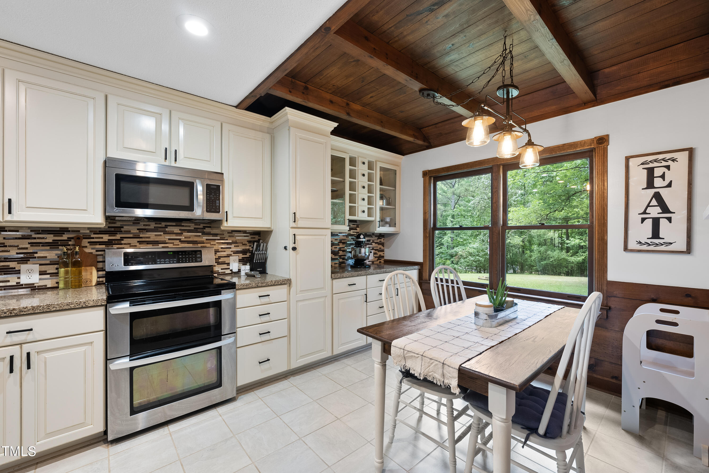 6319 Carbonton Road Sanford, NC 27330 - Photo 7 of 19 a kitchen with stainless steel appliances granite countertop a stove a refrigerator a kitchen island a sink dishwasher a dining table and chairs with wooden floor