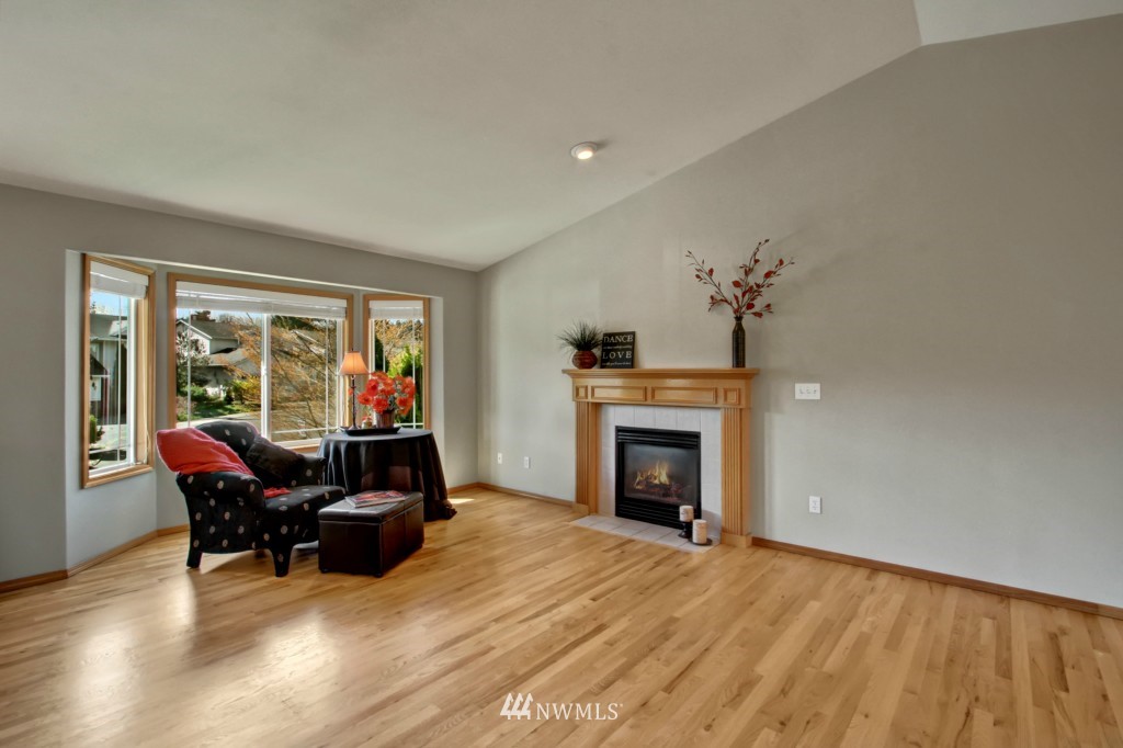 24219 13th Place West Bothell, WA 98021 - Photo 6 of 18 a living room with furniture a fireplace and a floor to ceiling window