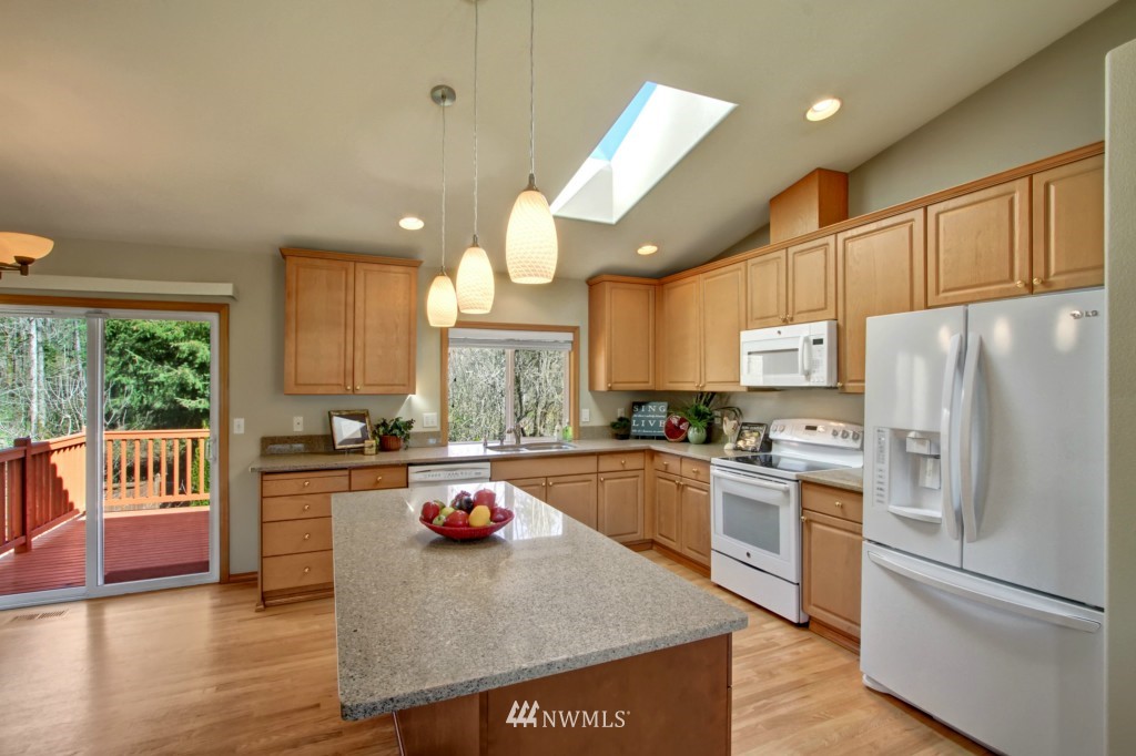 24219 13th Place West Bothell, WA 98021 - Photo 8 of 18 a kitchen with granite countertop a refrigerator a sink dishwasher a stove and white cabinets with wooden floor