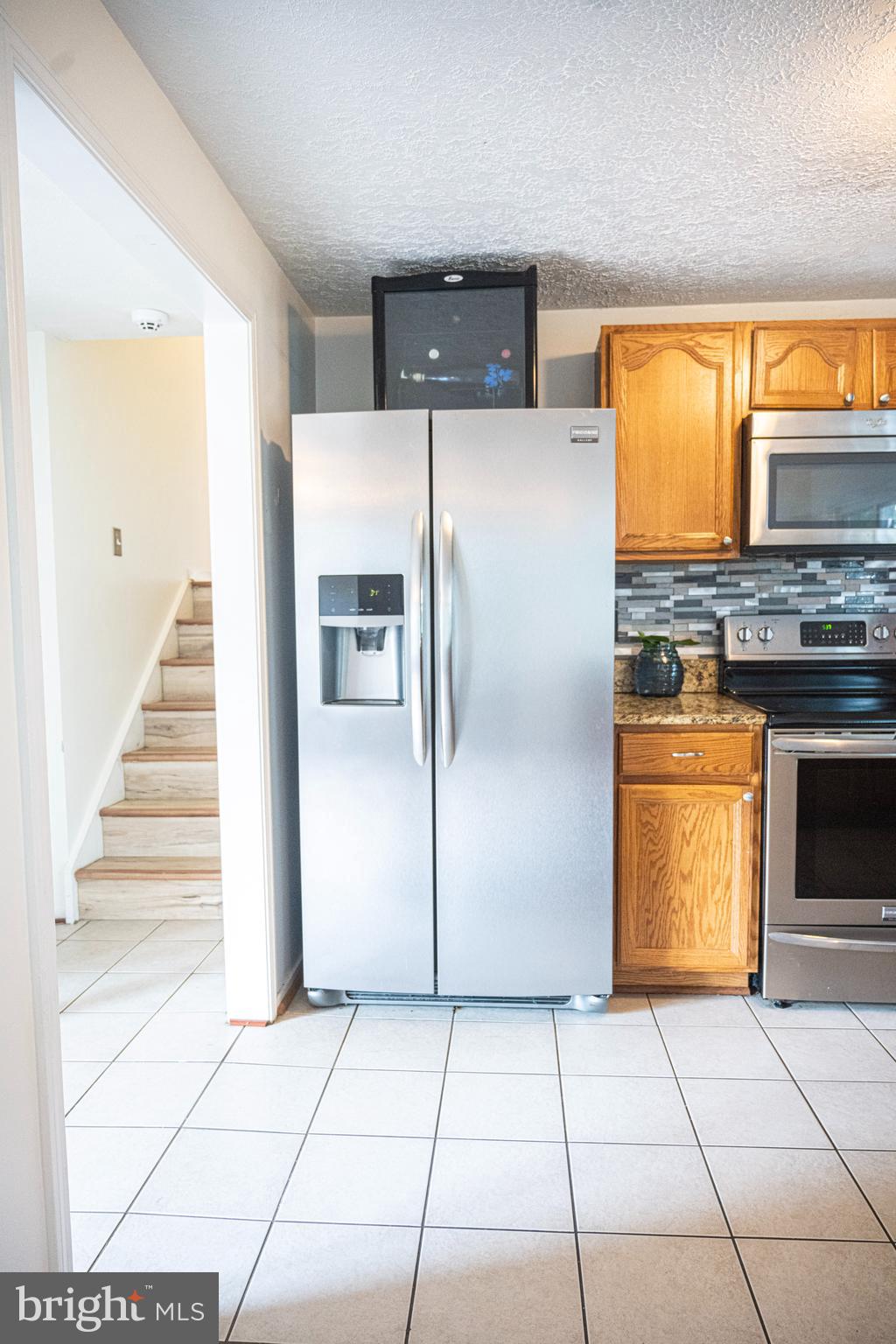 3115 Northmont Road Windsor Mill, MD 21244 - Photo 13 of 49 a kitchen with a refrigerator a stove a washer and dryer