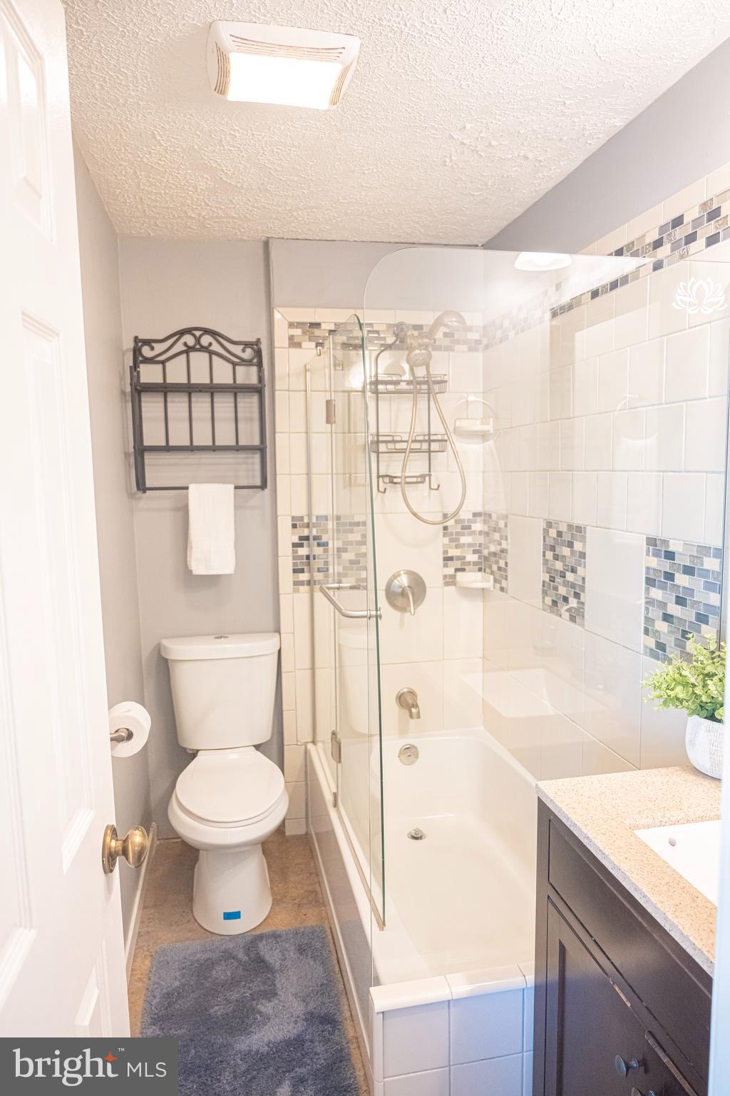 3115 Northmont Road Windsor Mill, MD 21244 - Photo 32 of 49 a bathroom with a granite countertop sink a toilet a mirror and shower
