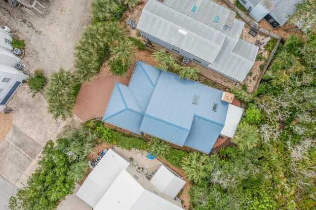a backyard of a house with table and chairs under an umbrella