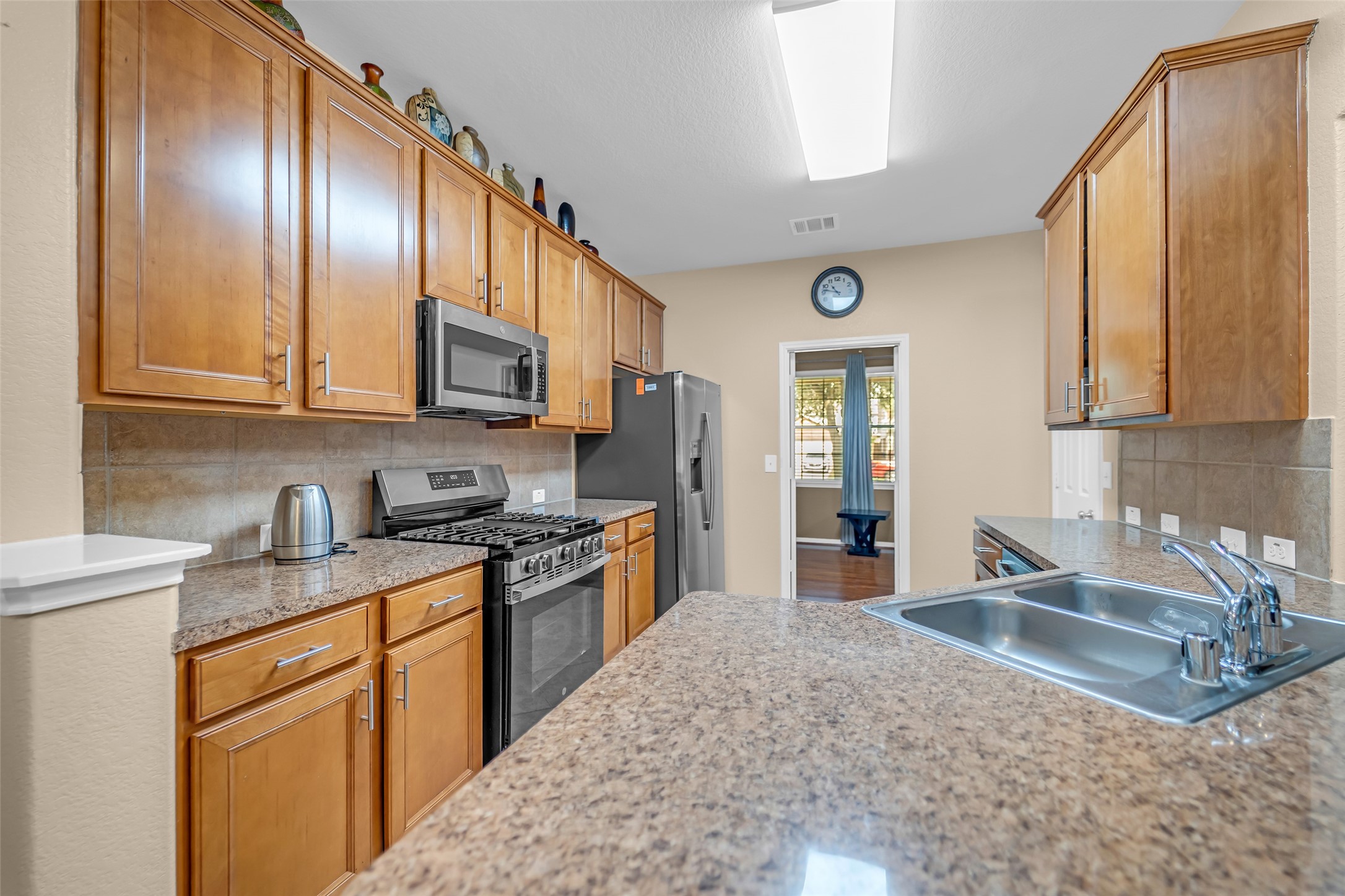 5406 Quarry Ridge Road Richmond, TX 77407 - Photo 16 of 36 Open-concept kitchen with abundant cabinetry, expansive countertop workspace, stainless steel appliances, and a spacious breakfast bar designed for effortless cooking, gathering, and everyday connection.