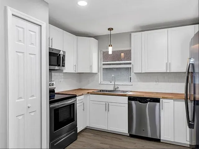 a kitchen with stainless steel appliances white cabinets and a sink