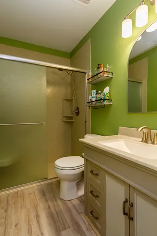 a bathroom with a granite countertop toilet sink and mirror