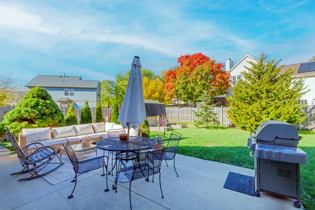 a backyard of a house with a garden and barbeque oven