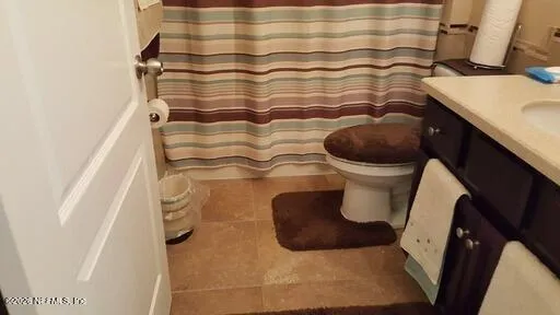 a bathroom with a toilet and a shower curtain