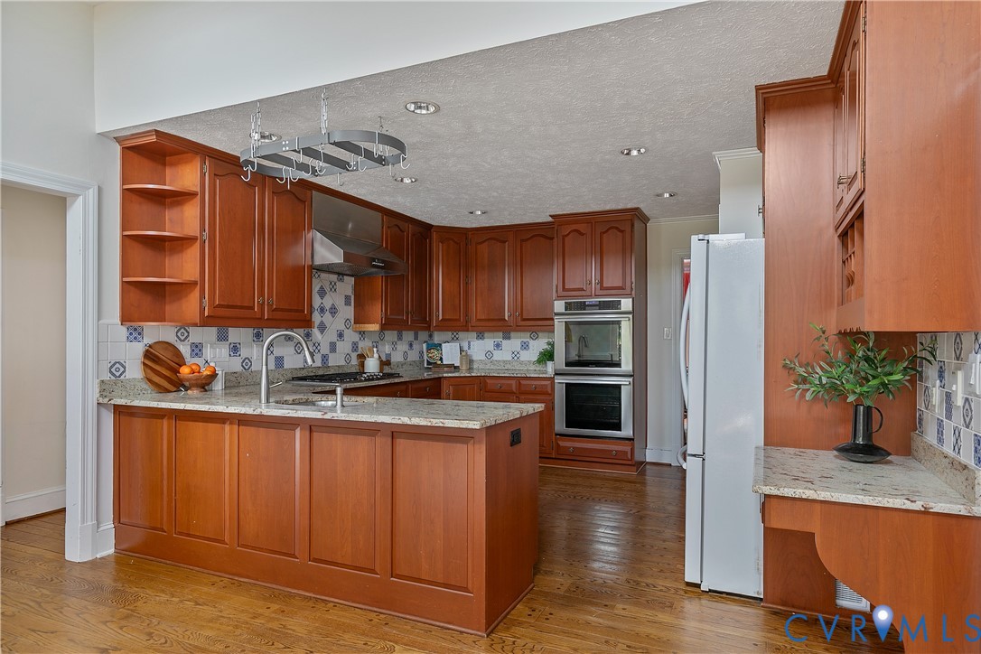 10000 Ramsbury Way Richmond, VA 23238 - Photo 20 of 59 a kitchen with stainless steel appliances granite countertop a refrigerator a stove and a wooden floors