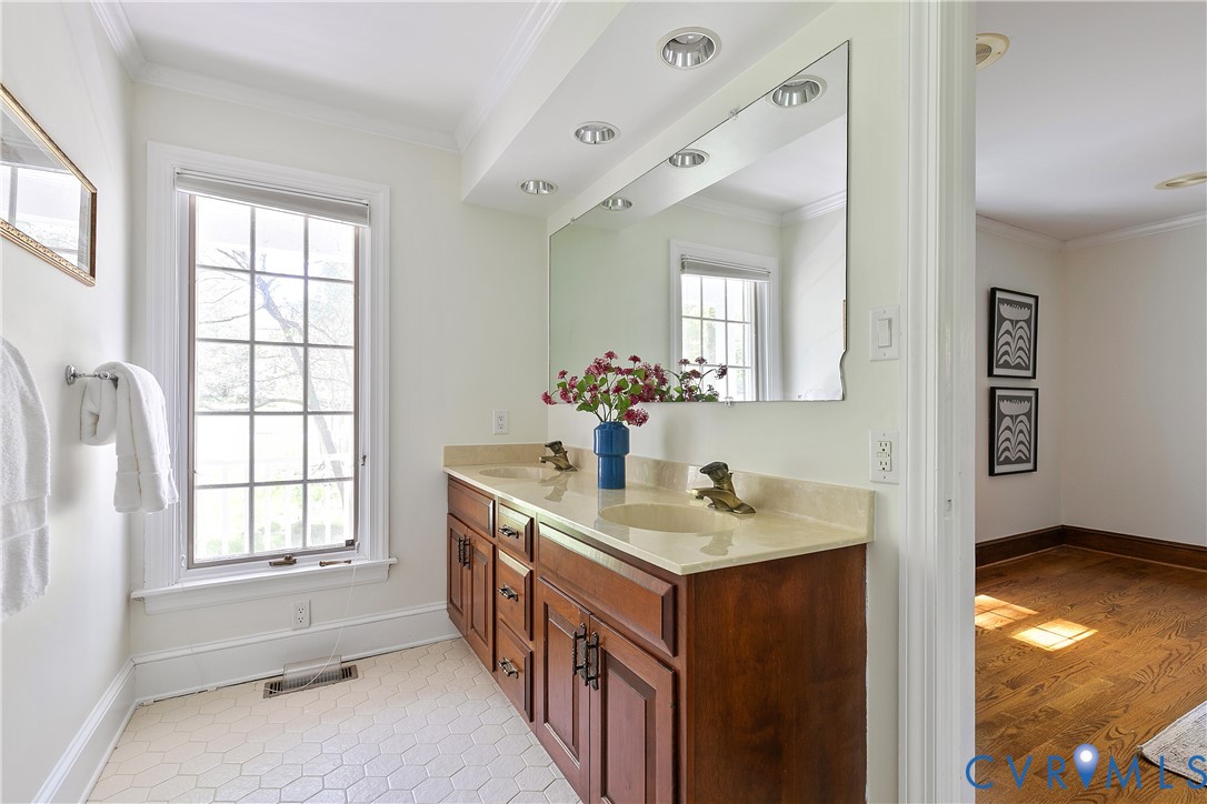 10000 Ramsbury Way Richmond, VA 23238 - Photo 33 of 59 a bathroom with a sink a mirror and a bathtub next to a window