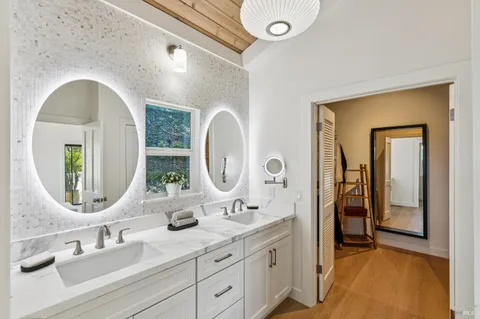a kitchen with stainless steel appliances granite countertop a dining table chairs refrigerator and cabinets