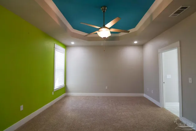 an empty room with a window and ceiling fan