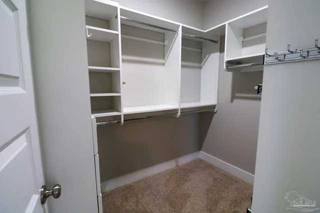 a view of walk in closet with empty racks