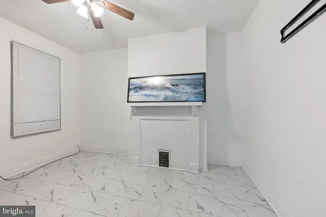 an empty room with chandelier fan