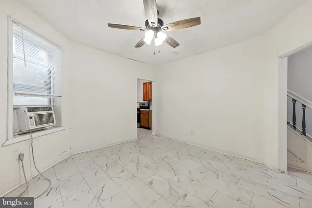 en empty room with windows and ceiling fan