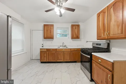 a large kitchen with stainless steel appliances granite countertop a stove a sink and a refrigerator