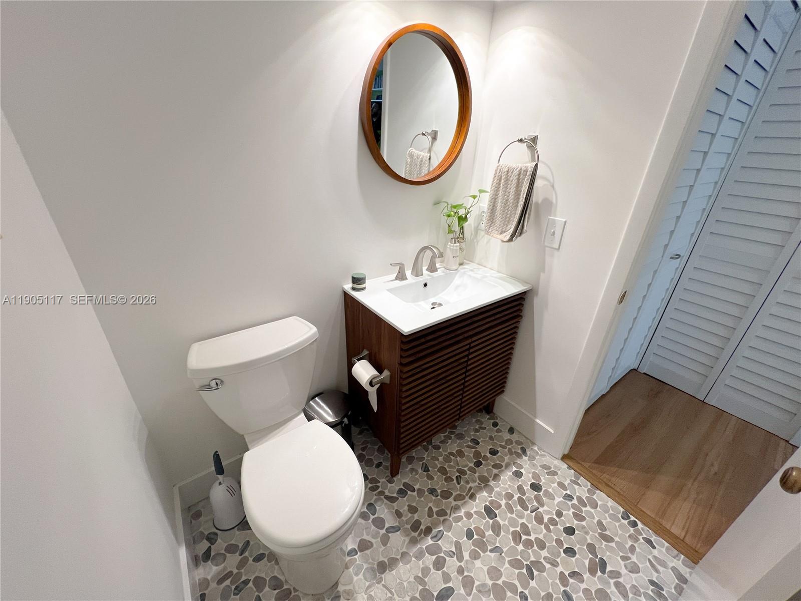 4555 Southwest 68th Ct Circle, Unit 111 Miami, FL 33155 - Photo 23 of 33 a bathroom with a toilet a sink and a mirror