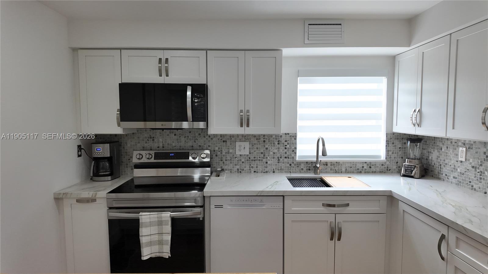 4555 Southwest 68th Ct Circle, Unit 111 Miami, FL 33155 - Photo 8 of 33 a kitchen with white cabinets stainless steel appliances and a sink