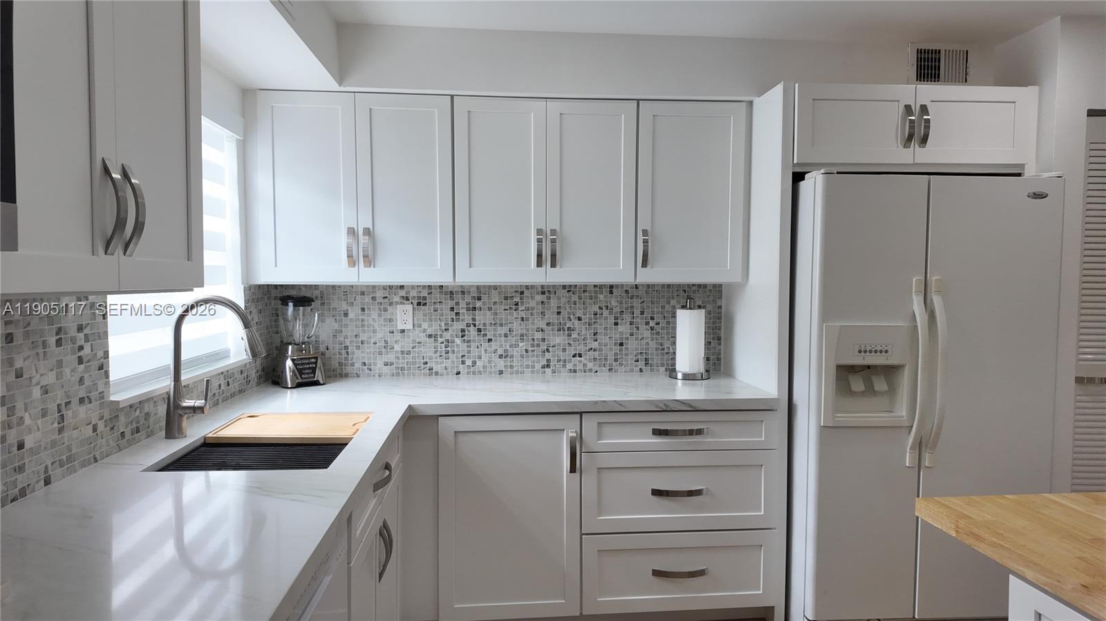 4555 Southwest 68th Ct Circle, Unit 111 Miami, FL 33155 - Photo 9 of 33 a kitchen with granite countertop white cabinets and refrigerator