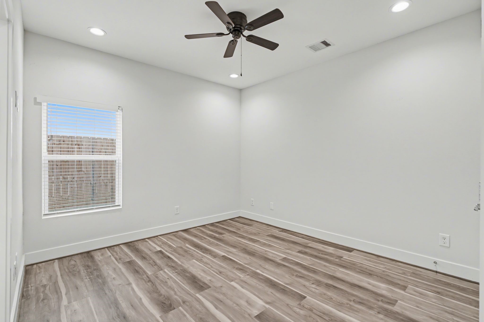 2502 West Tidwell Road, Unit D Houston, TX 77091 - Photo 3 of 24 wooden floor in an empty room with a window