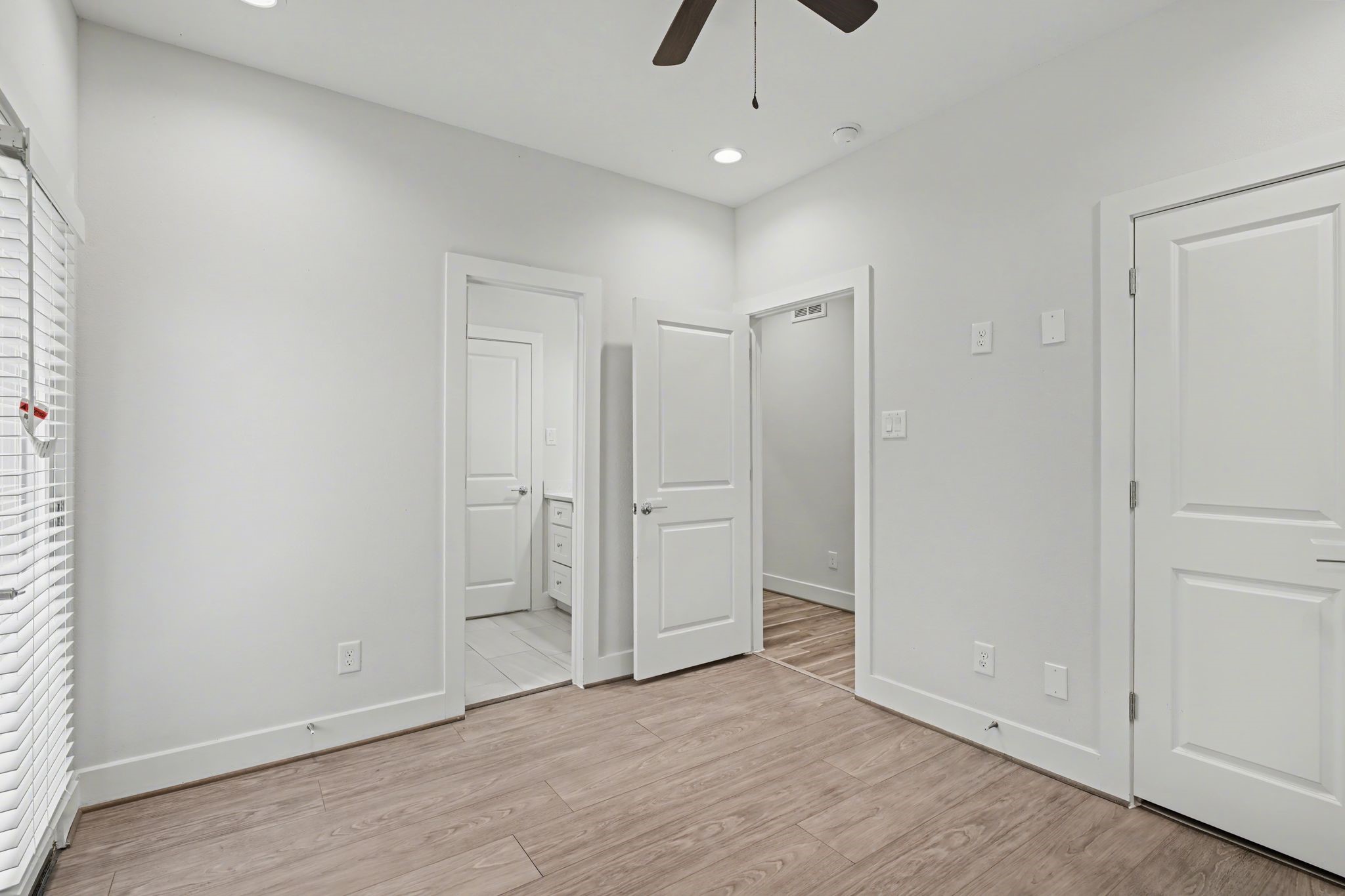 2502 West Tidwell Road, Unit D Houston, TX 77091 - Photo 8 of 24 an empty room with wooden floor and ceiling fan