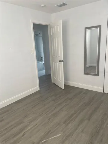 an empty room with wooden floor and closet