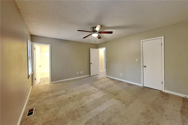 an empty room with closet and a chandelier fan