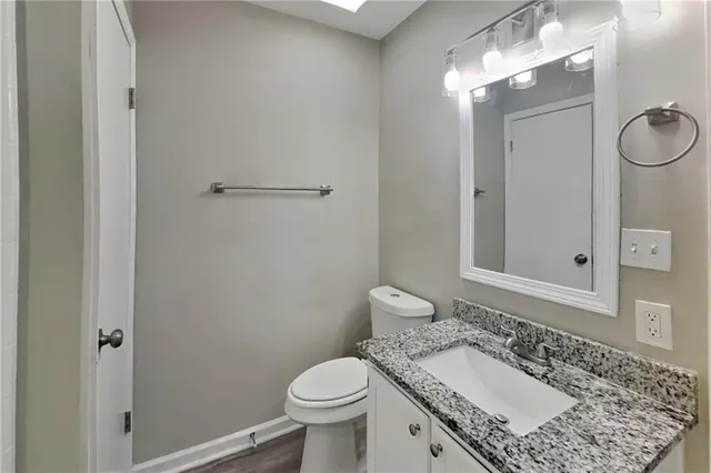 a bathroom with a granite countertop sink toilet and shower