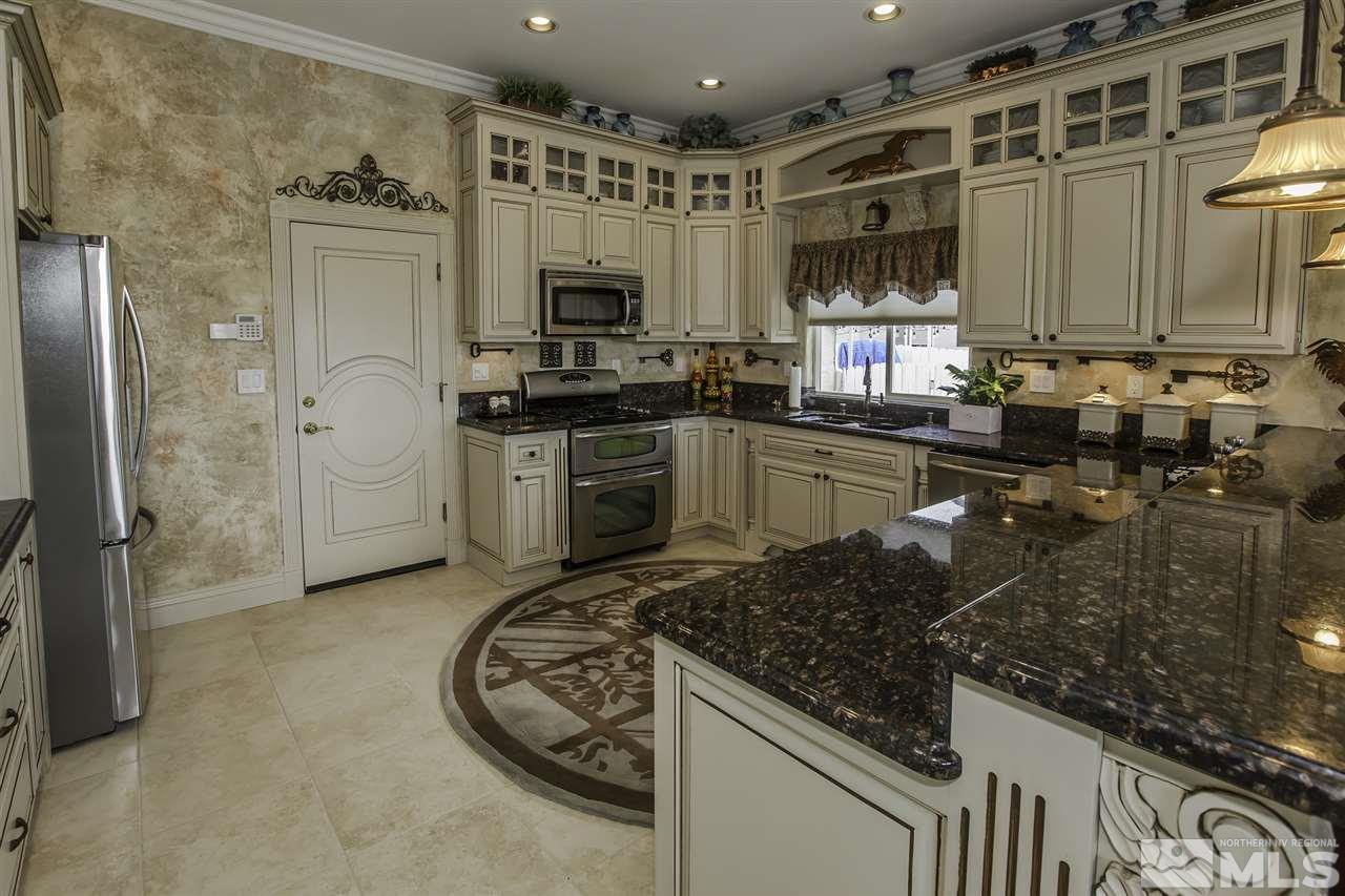 950 Stadium View Court Reno, NV 89512 - Photo 4 of 25 a kitchen with stainless steel appliances granite countertop a sink stove and refrigerator