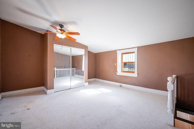 an empty room with windows and fireplace