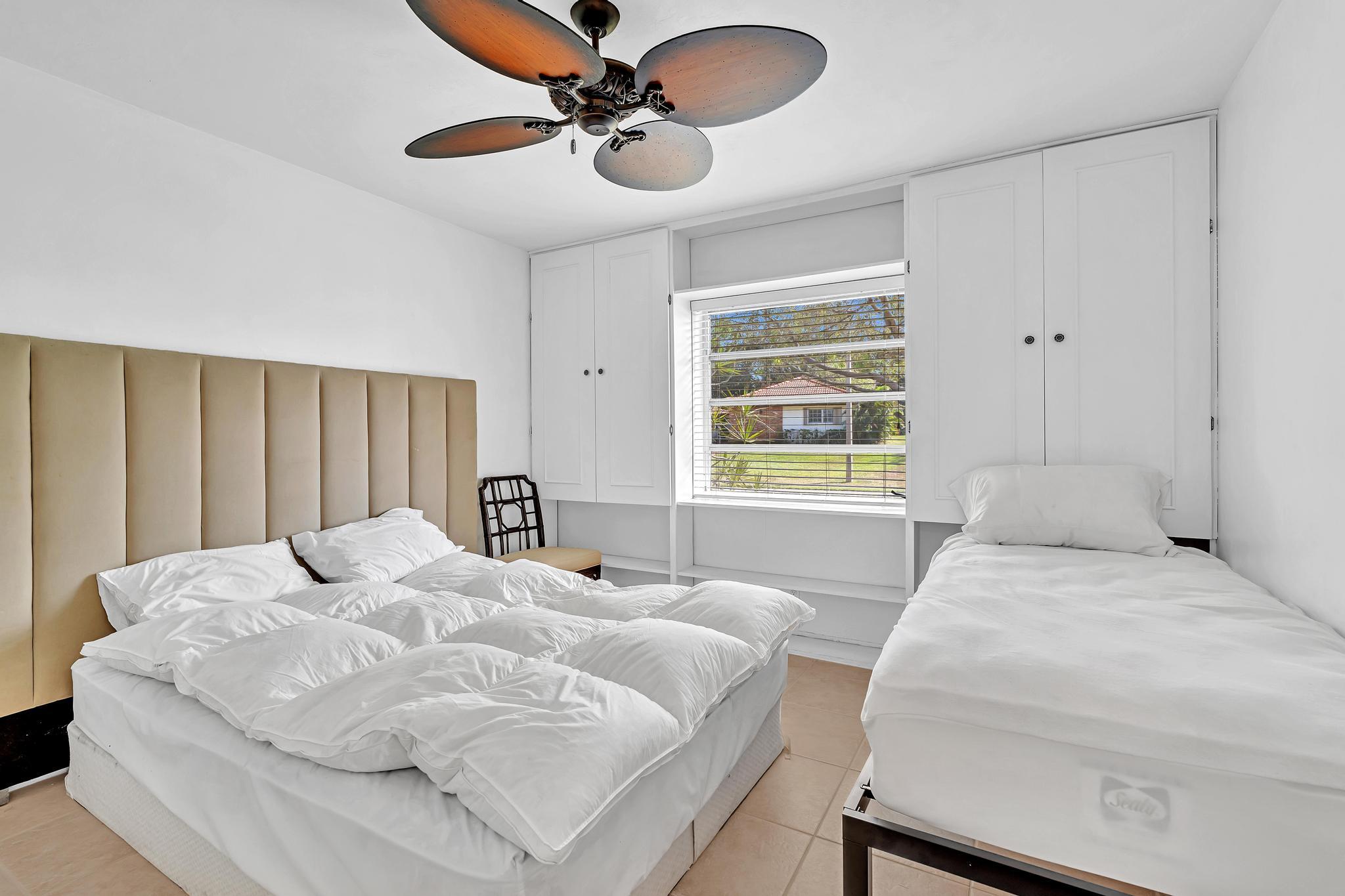 313 Northwest 42nd Street Boca Raton, FL 33431 - Photo 19 of 42 a bedroom with a large bed and a chandelier