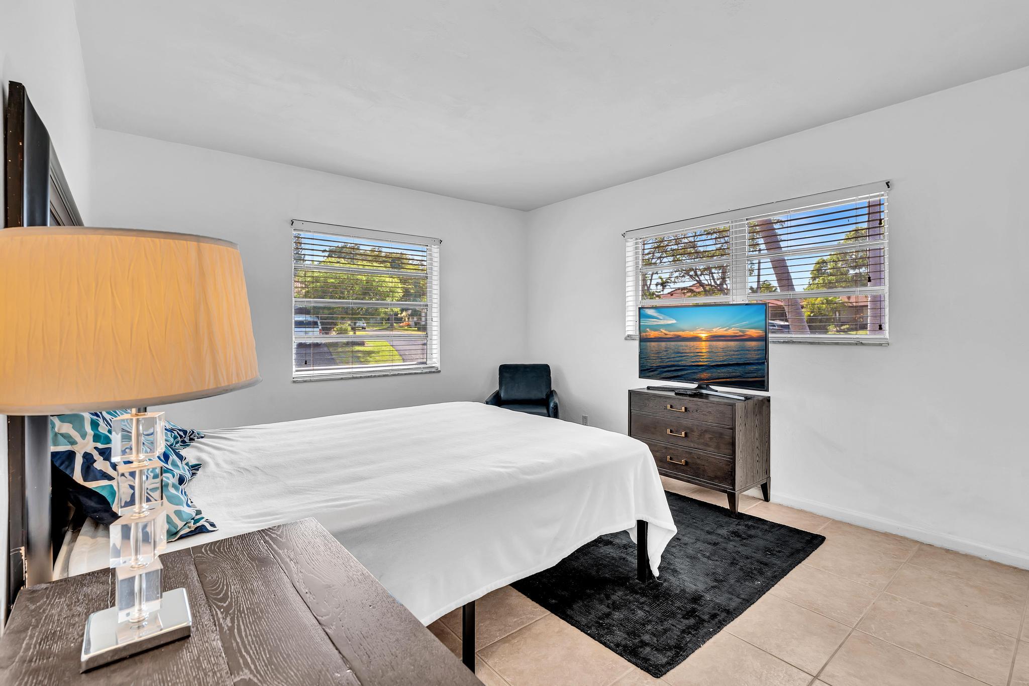 313 Northwest 42nd Street Boca Raton, FL 33431 - Photo 20 of 42 a bedroom with a bed a dresser and next to a window