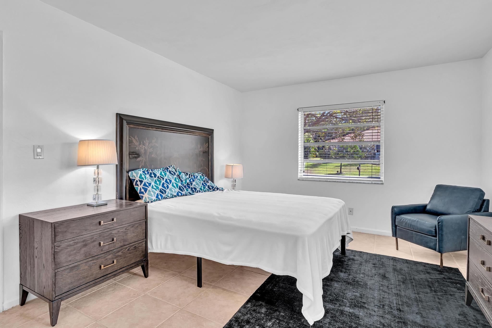 313 Northwest 42nd Street Boca Raton, FL 33431 - Photo 21 of 42 a bed room with a bed window and a table in it