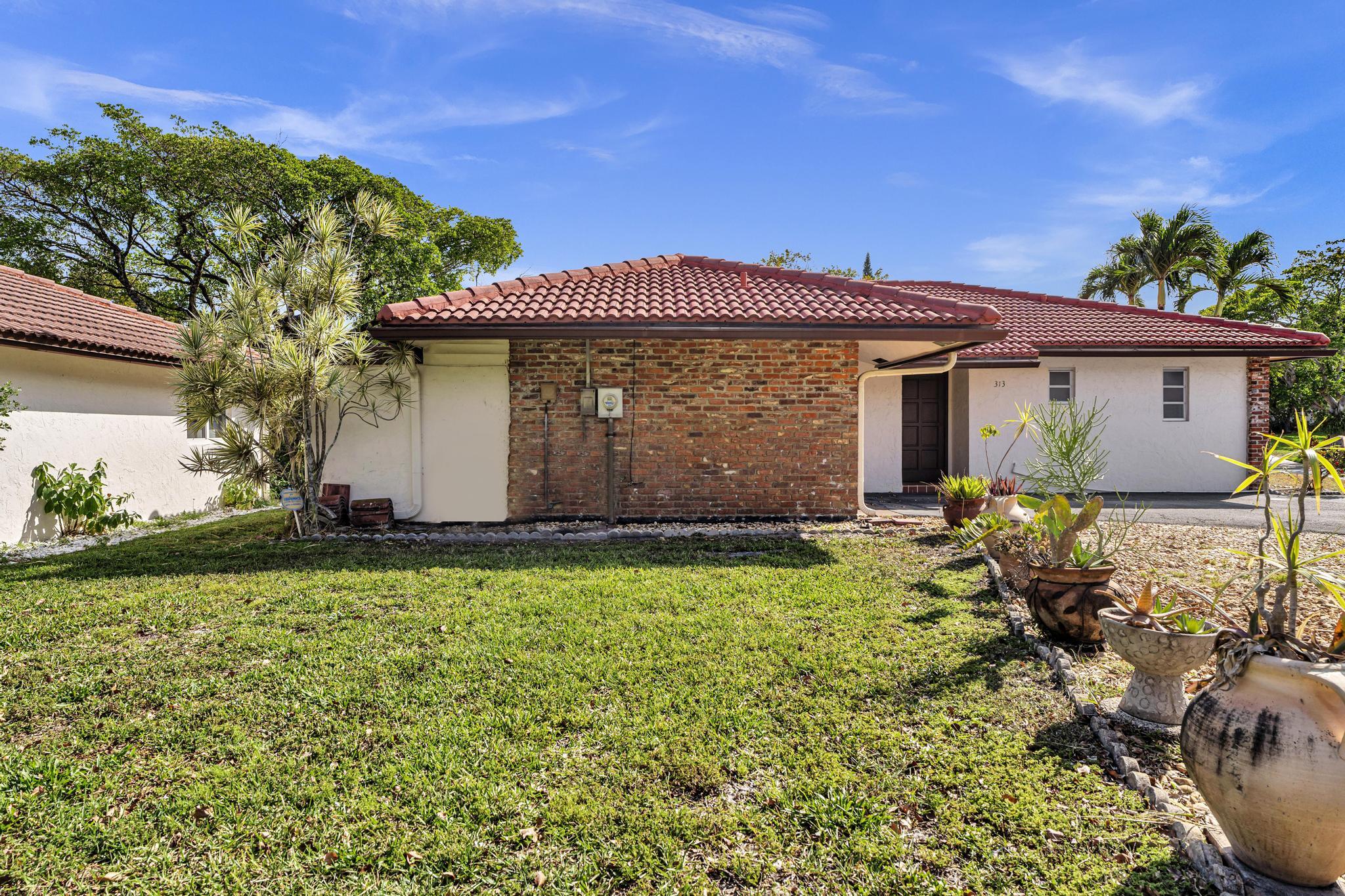 313 Northwest 42nd Street Boca Raton, FL 33431 - Photo 33 of 42 a front view of a house with garden
