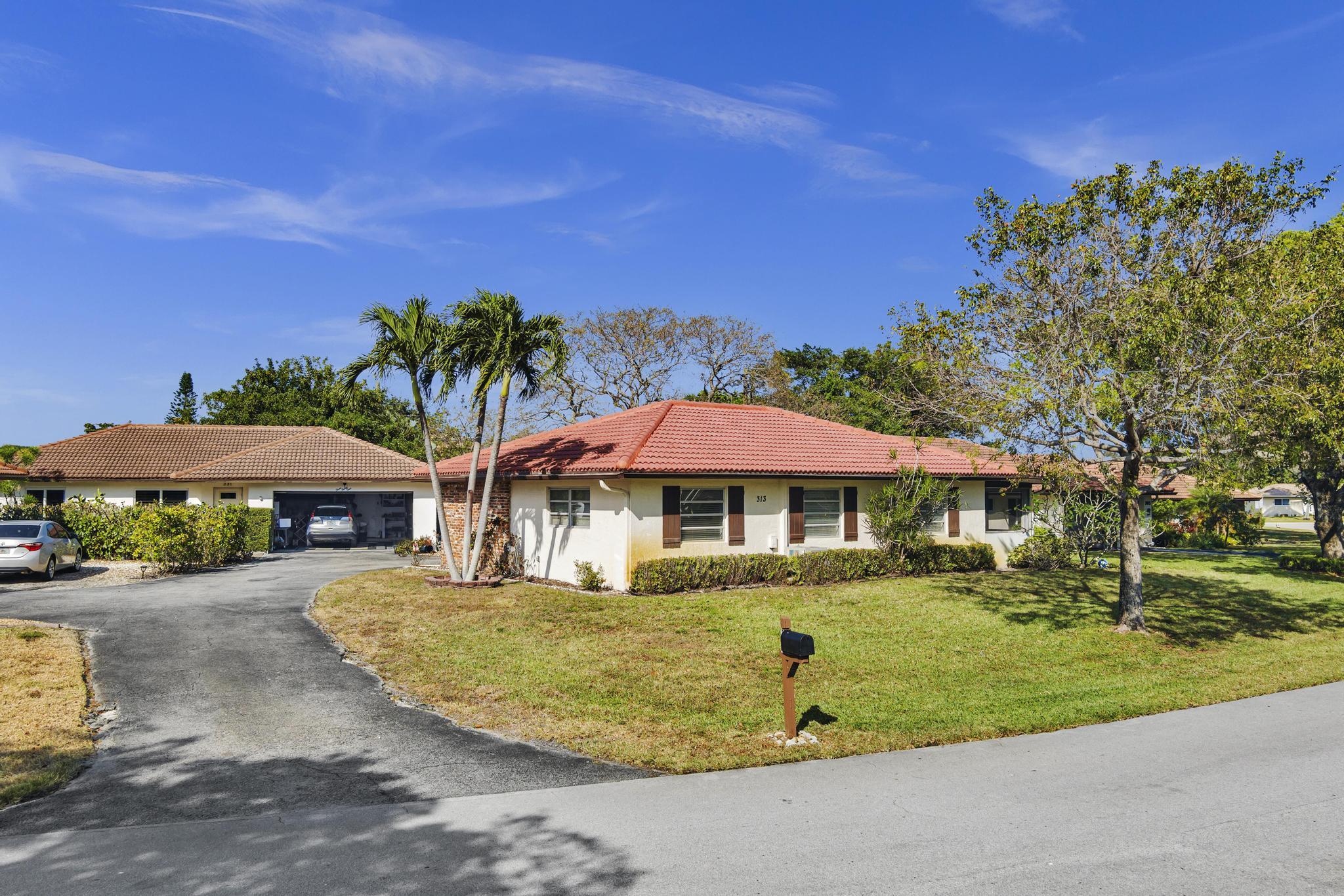 313 Northwest 42nd Street Boca Raton, FL 33431 - Photo 37 of 42 a view of a patio with table and chairs under an umbrella