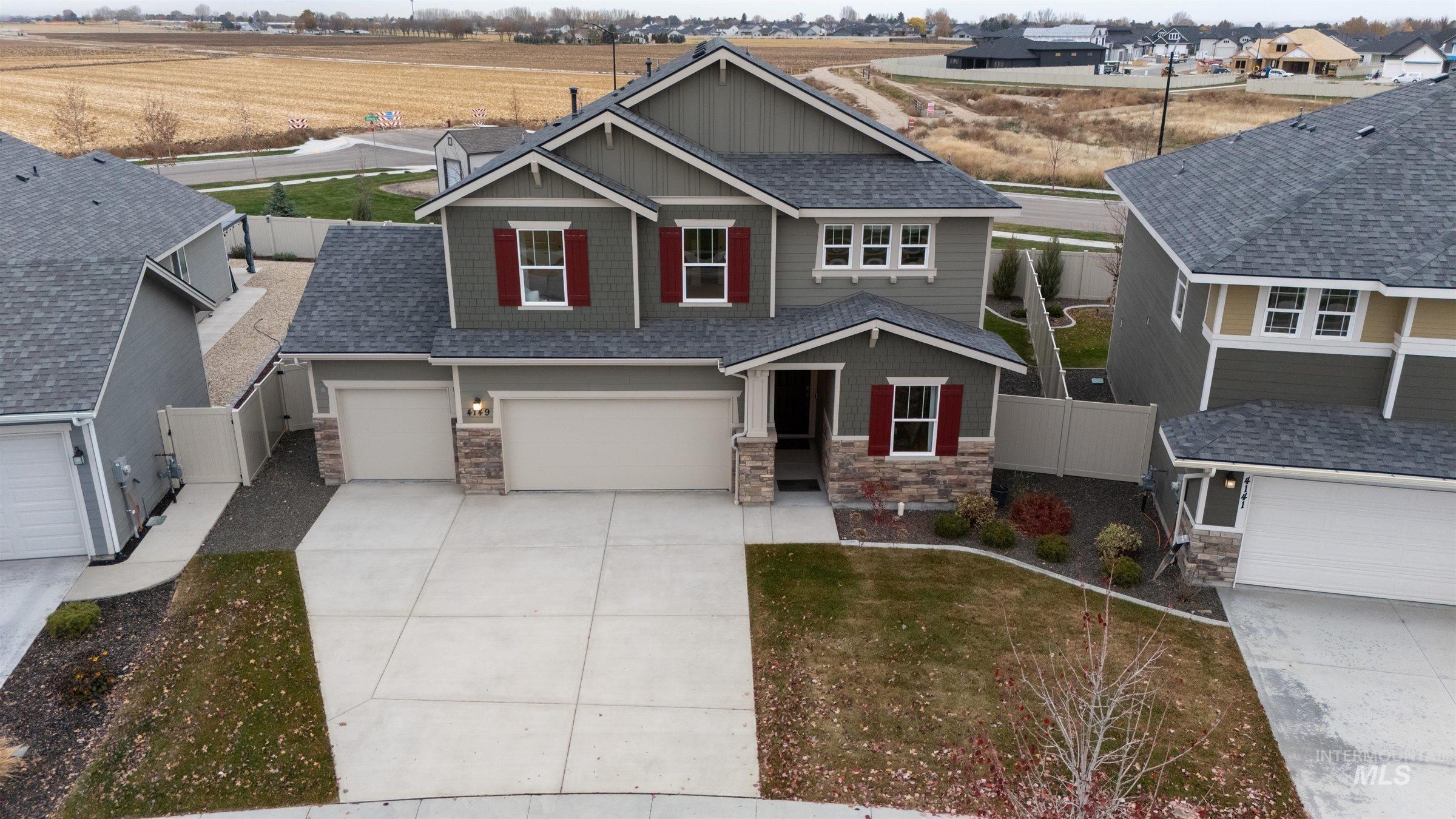 4149 South Colditz Way Meridian, ID 83642 - Photo 35 of 42 Craftsman-style home with stone siding, concrete driveway, a shingled roof, board and batten siding, and a garage