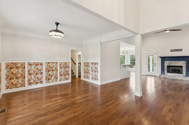 an empty room with wooden floor cabinet and windows
