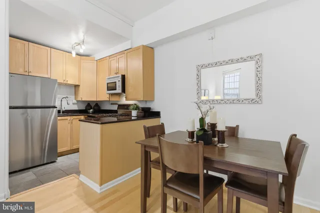 a kitchen with a dining table chairs and refrigerator