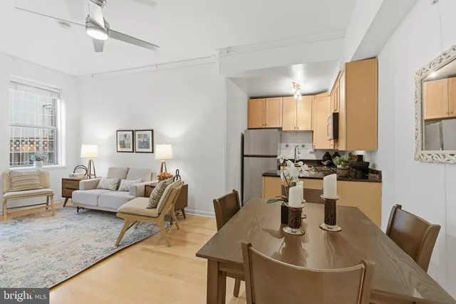 a living room with furniture kitchen view and a window